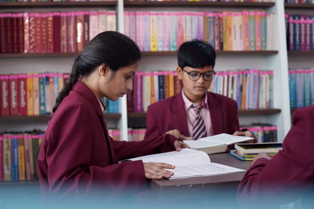 Two students reading together at a library desk